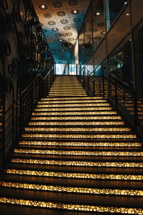 un escalier dans le passage Pommeray à Nantes. Celui-ci n'est pas le classique en bois que tout le monde connait, mais un escalier récent. Bien sûr pour faciliter son intégration ce dernier revêt un habillage ciselé et un rétro-éclairage dans les tons jaunes. Un escalier tout en dentelle