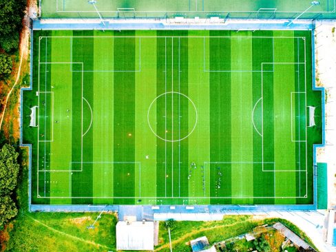 Vue aérienne d'un terrain de football en synthétique. L'équipement mis à disposition par la ville de Lorient est tout neuf. Des lignes verts tendres succèdent aux lignes vert foncé.