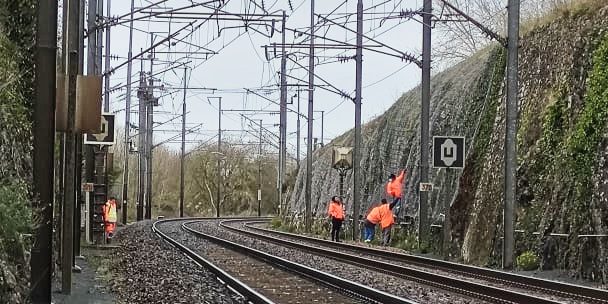 SDCH-Voies Ferrées-INGRANDES Des hommes vêtus de orange vérifient et inspectent les derniers travaux de renforcement d'une paroi en bordure de voie ferrée. Des prises de vues techniques par drone seront effectuées pour l'établissement du DOE