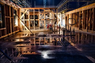 Suivi nocturne de chantier. Une ossature bois est en train d'être levée, les compagnons s'organisent.