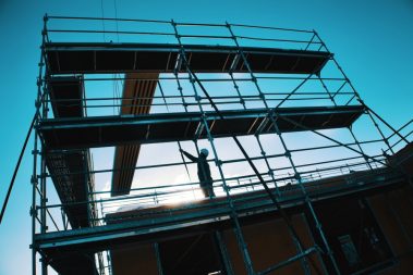 Un ouvrier réceptionne un panneau de toiture en OSB lors d'un levage. Cette photographie a été prise lors d'un suivi de chantier