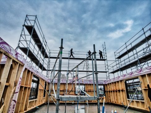 Les compagnons finissent leur journée et montent sur l'échafaudage afin de constater l'avancée des travaux après une journée complète de levage.