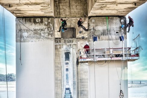Des cordistes sont en train d'effectuer des travaux sous le pont de Noirmoutier. Olao a été mandatée pour réaliser un suivi vidéo et photographique de ce chantier.