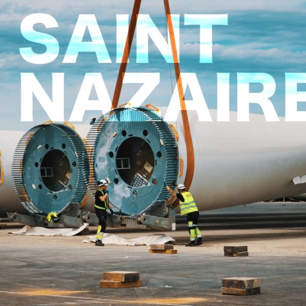 EOLE ST NAZ Prises de vues lors d'un suivi de chantier sur le port à St Nazaire sur le môle dédié aux éoliennes en mer. Deux hommes portant leurs E.P.I sont en train de poser les sangles à une pale d'éolienne. Travaux sur le port autonome