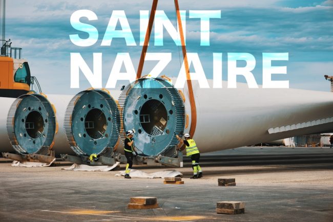 EOLE ST NAZ Prises de vues lors d'un suivi de chantier sur le port à St Nazaire sur le môle dédié aux éoliennes en mer. Deux hommes portant leurs E.P.I sont en train de poser les sangles à une pale d'éolienne. Travaux sur le port autonome