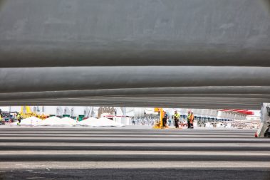 Des ouvriers improvisent une réunion avant le chargement des pièces d'éoliennes