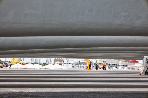 Des ouvriers improvisent une réunion avant le chargement des pièces d'éoliennes