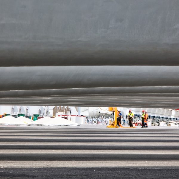 Pales Des ouvriers improvisent une réunion avant le chargement des pièces d'éoliennes