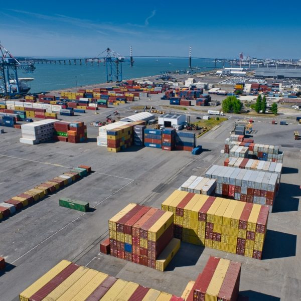 Port de St Nazaire Vue aérienne par drone du port de St Nazaire. Au premier plan, des containers à dominante jaune et couleur lie de vin, les fameux portiques bleus et dans le fond, le pont de St Nazaire