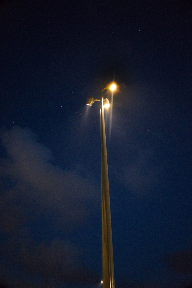 Mât d'éclairage public allumé sous un ciel de nuit à Plœmeur, reportage pour Spie