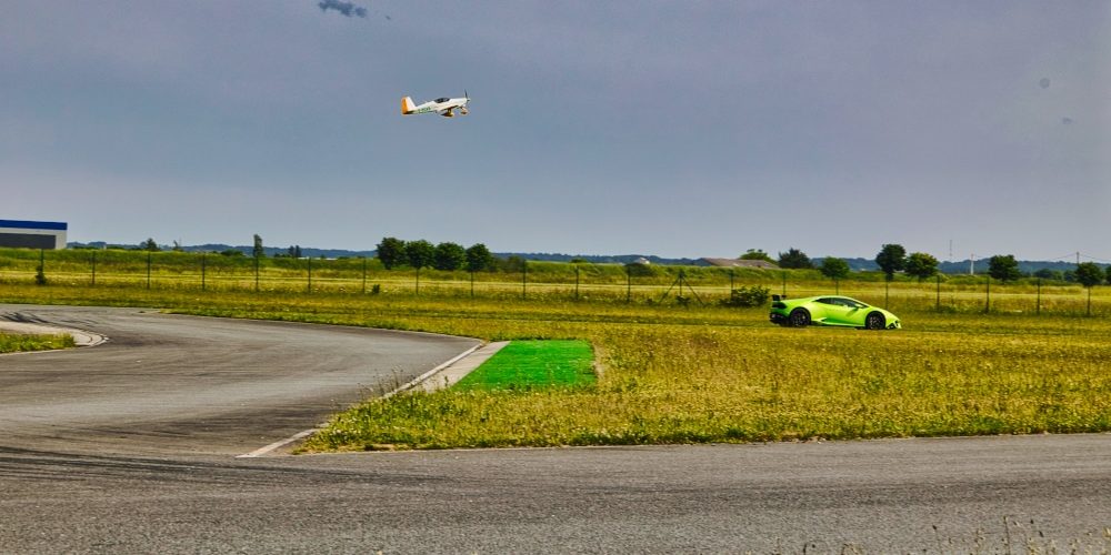 Edition Kiwanis 2023. Une course entre une voiture verte de sport et un avion de tourisme lors de la journée dédiée à l'association Kiwanis à Fontenay le Comte