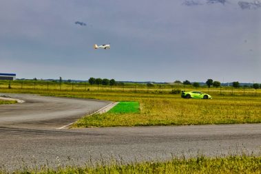 Edition Kiwanis 2023. Une course entre une voiture verte de sport et un avion de tourisme lors de la journée dédiée à l'association Kiwanis à Fontenay le Comte