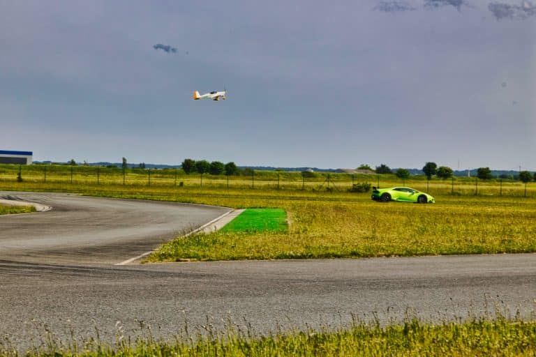 Edition Kiwanis 2023. Une course entre une voiture verte de sport et un avion de tourisme lors de la journée dédiée à l'association Kiwanis à Fontenay le Comte