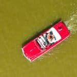 une voiture amphibie rouge se promène dans un étang en Bretagne