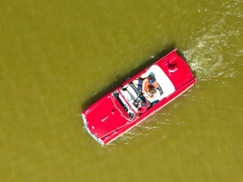 une voiture amphibie rouge se promène dans un étang en Bretagne