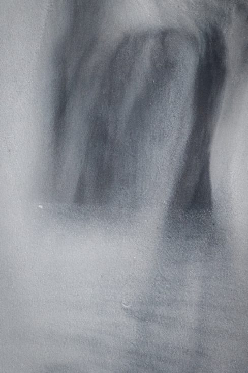 des formes abstraites se dessinent dans le sable gris de l'hiver