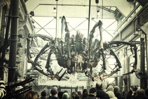 Elle s'élève par dessus la foule avec ses gros yeux rouges voici l'araignée des machines.