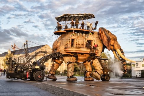 L'éléphant de la compagnie des machines se promène sur le parc des chantiers sous un soleil couchant