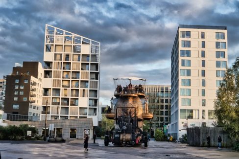 L'éléphant de l'île de Nantes se faufile entre deux immeubles comme il le ferait en entrant dans un magasin de porcelaine.