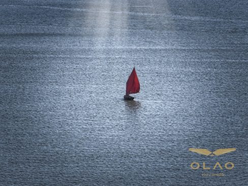 Un sinagot, le fameux bateau de séné dans le Morbihan. Il se caractérise par sa voile rouge. Un rayon de soleil vient frapper ce frêle esquif au milieu du Golfe du Morbihan.