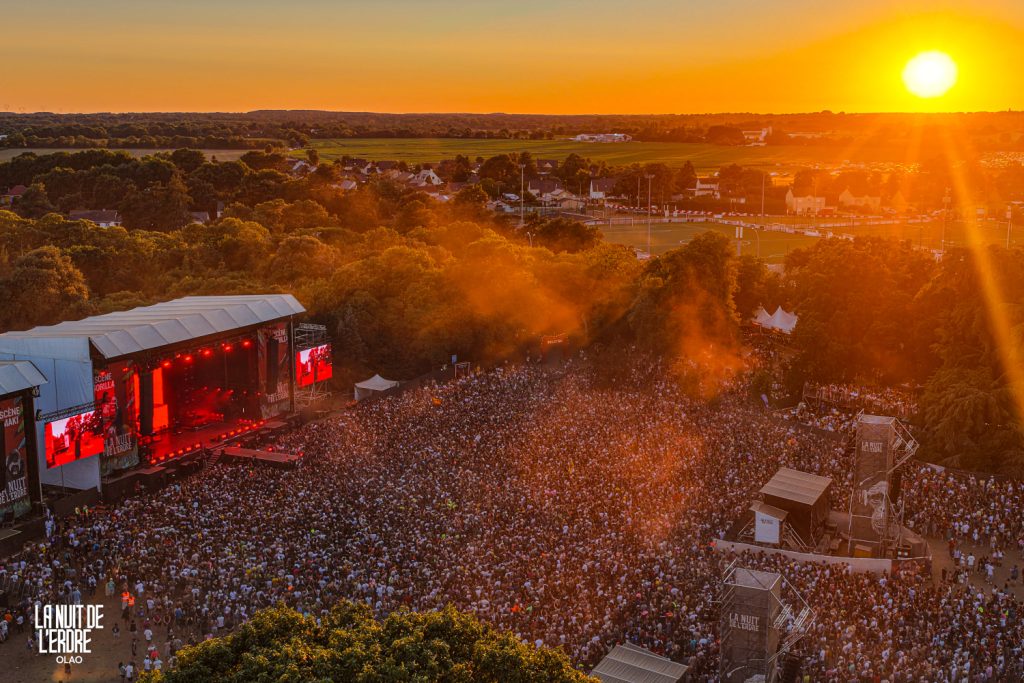 Coucher de soleil sur la grande scène de La Nuit de l'Erdre 2026, vue par drone au-dessus du public à Nort-sur-Erdre