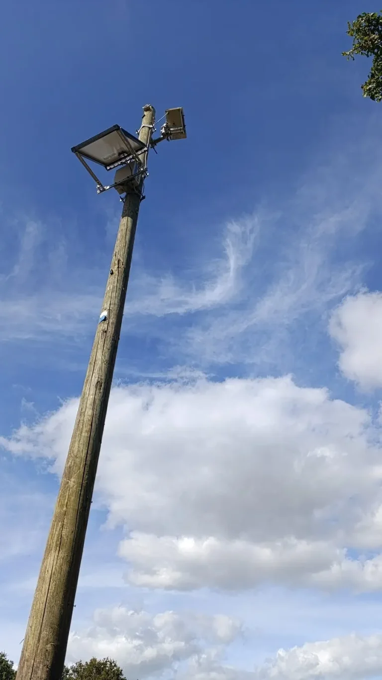 Caméra timelapse de chantier fixée en haut d'un poteau, alimentée par un panneau solaire